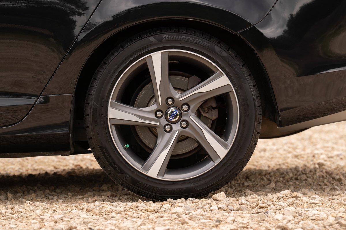 Close-up of a black 2015 Volvo V60 R-Design Polestar's 19-inch diamond cut alloy wheel and tire.