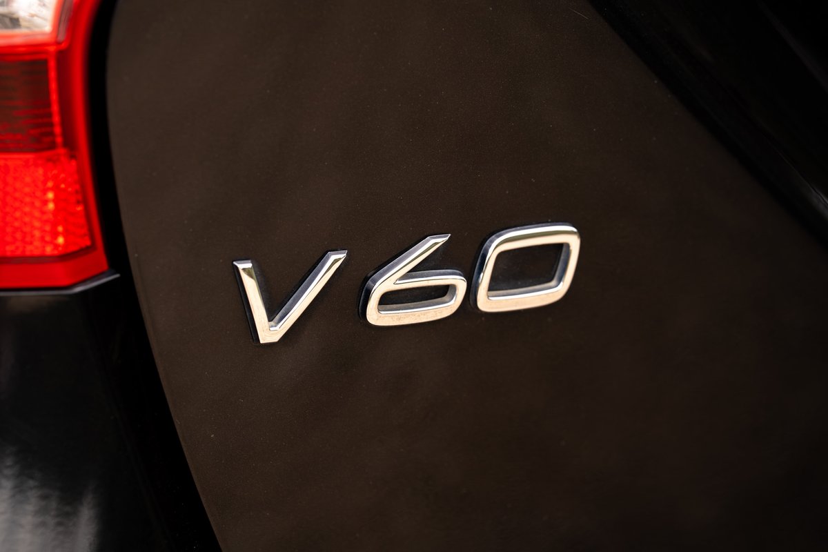 Close-up of chrome "V60" badge on a black 2015 Volvo V60 R-Design Polestar.