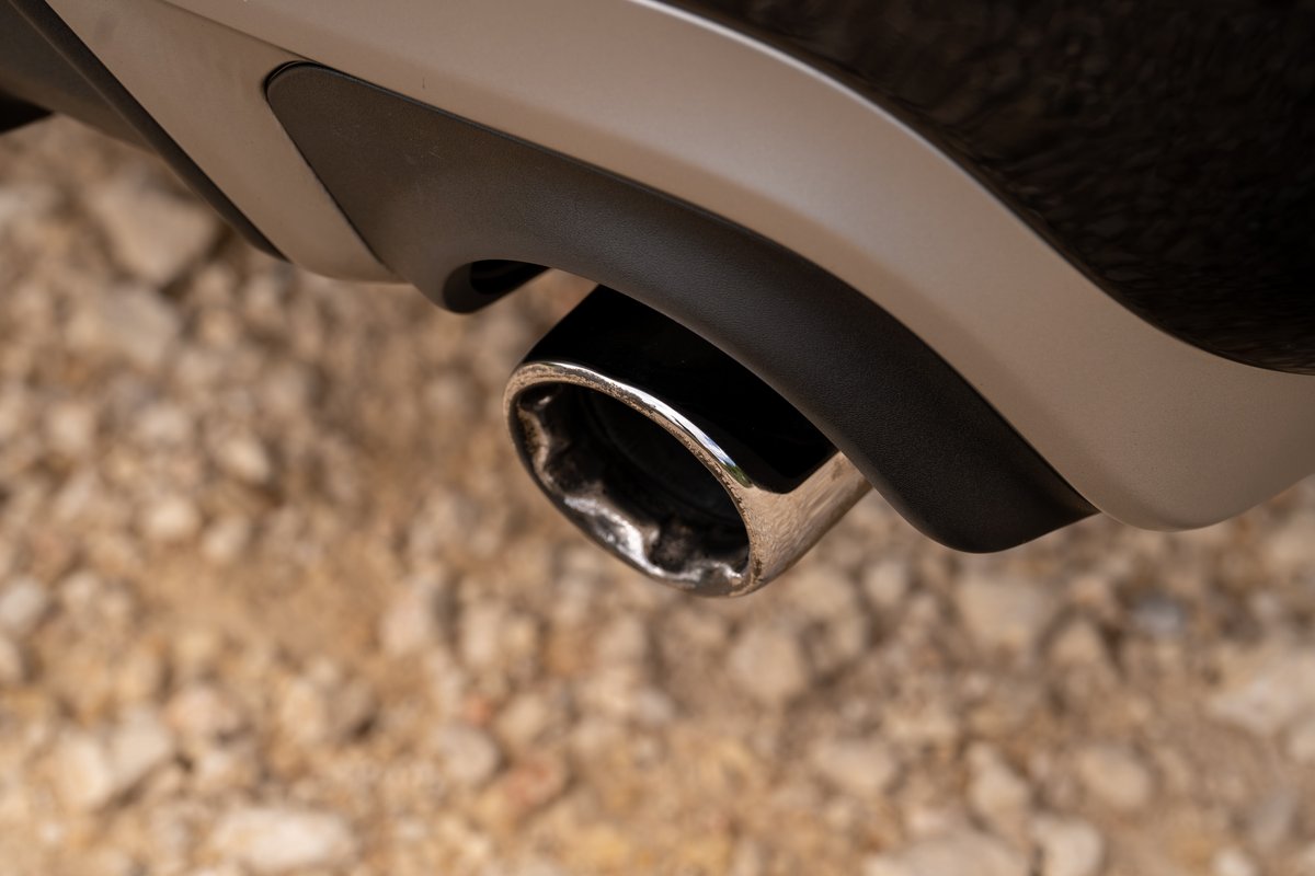Close-up of a chrome exhaust tip on a 2015 Volvo V60 R-Design Polestar with matte black diffuser trim.