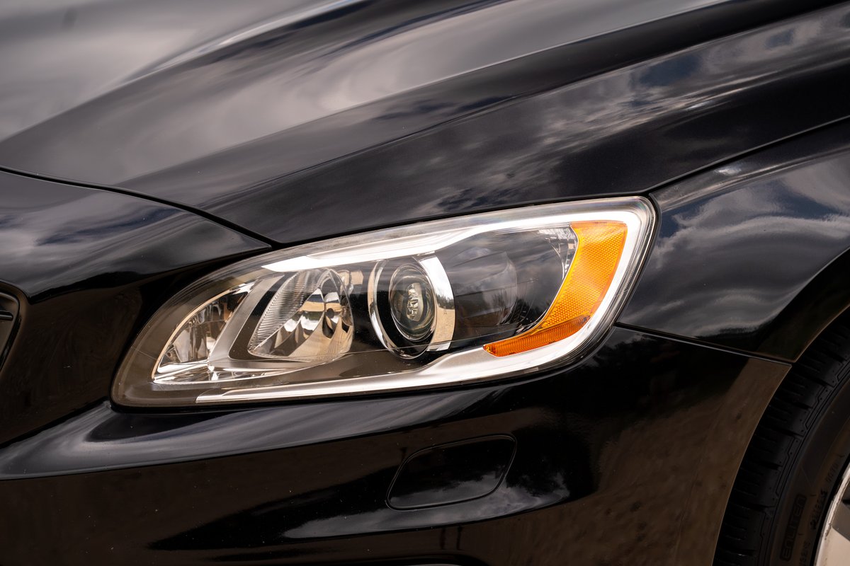 Black 2015 Volvo V60 R-Design Polestar headlight and fender detail.