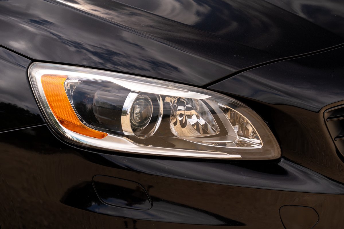 Black Volvo V60 R-Design Polestar headlight with chrome trim and amber marker.