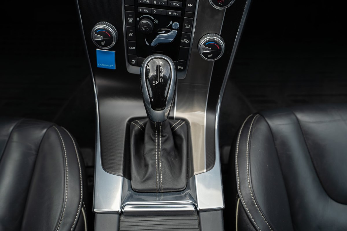 2015 Volvo V60 R-Design interior, showing the gear shifter and black leather seats.