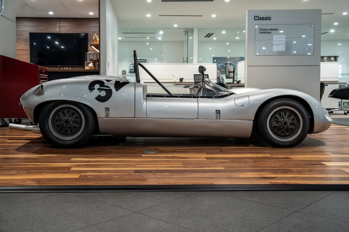 Silver 1964 Elva Porsche 4-Cam race car with black racing livery and multi-spoke rims.