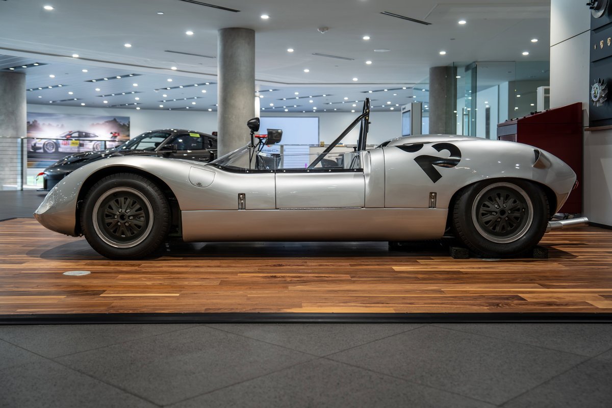 Silver 1964 Elva Porsche 4-Cam race car with black number '2' livery and black rims.