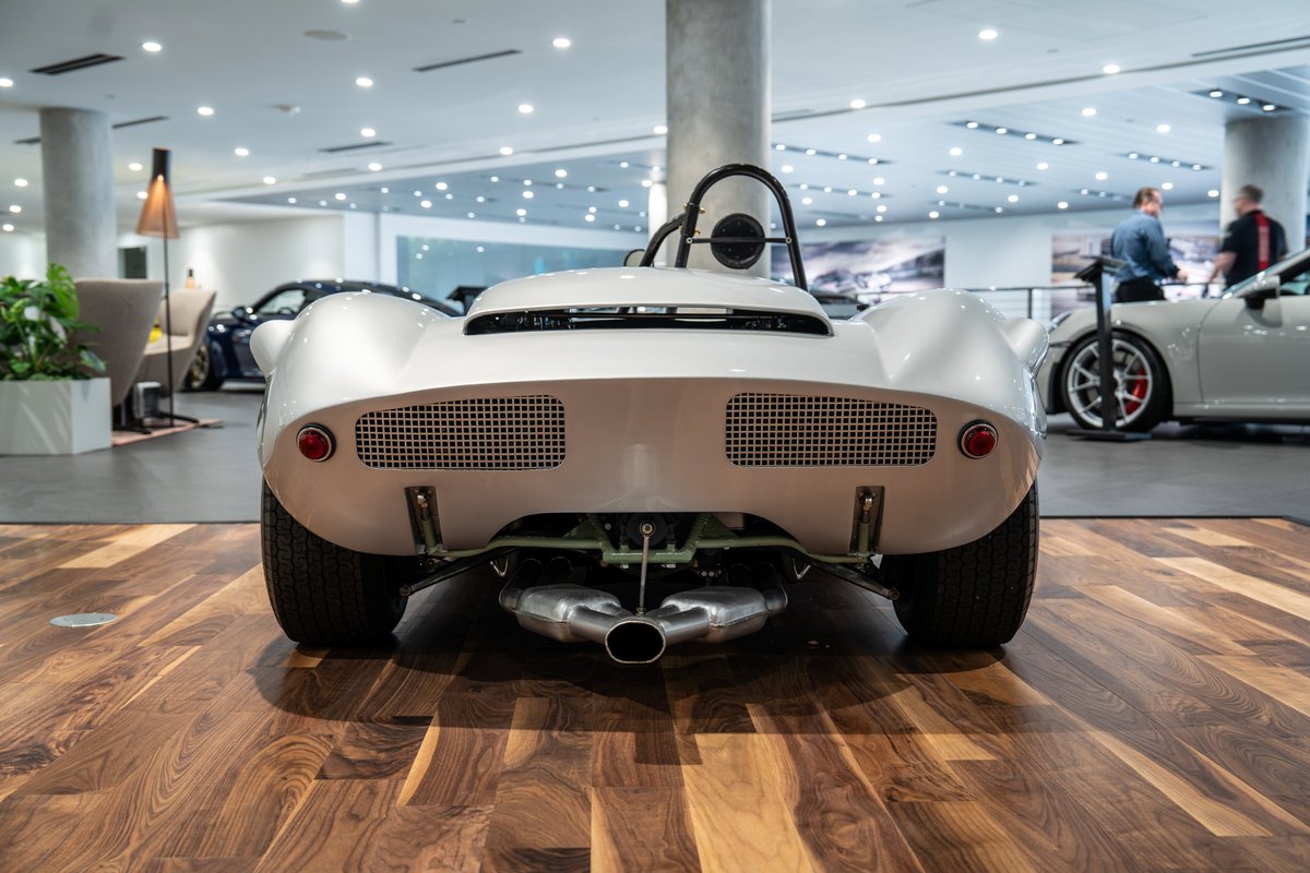 Rear view of a silver 1964 Elva Porsche 4-Cam with a dual exhaust and mesh grilles.