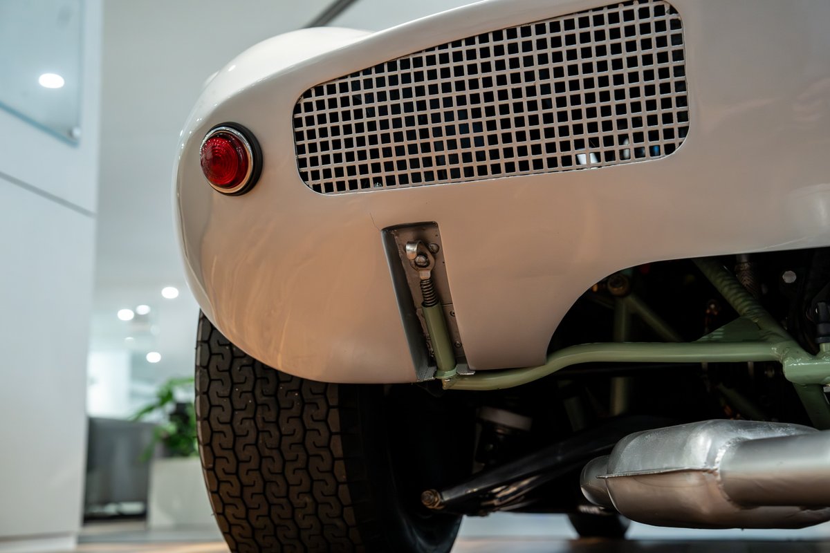 1964 Elva Porsche 4 Cam: Detail of the rear white bodywork, round taillight, and exhaust.