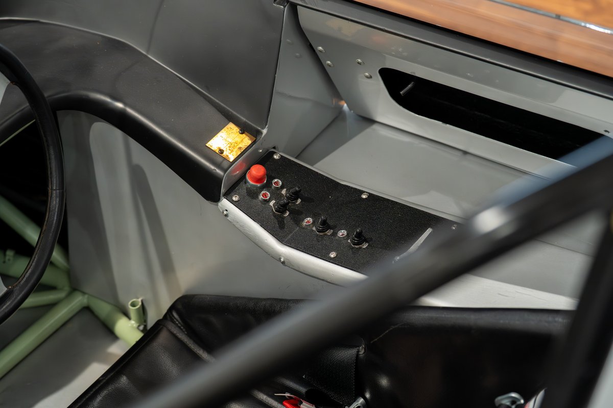 Close-up interior view of a 1964 Elva Porsche 4-Cam with toggle switches and a red button on the dash.
