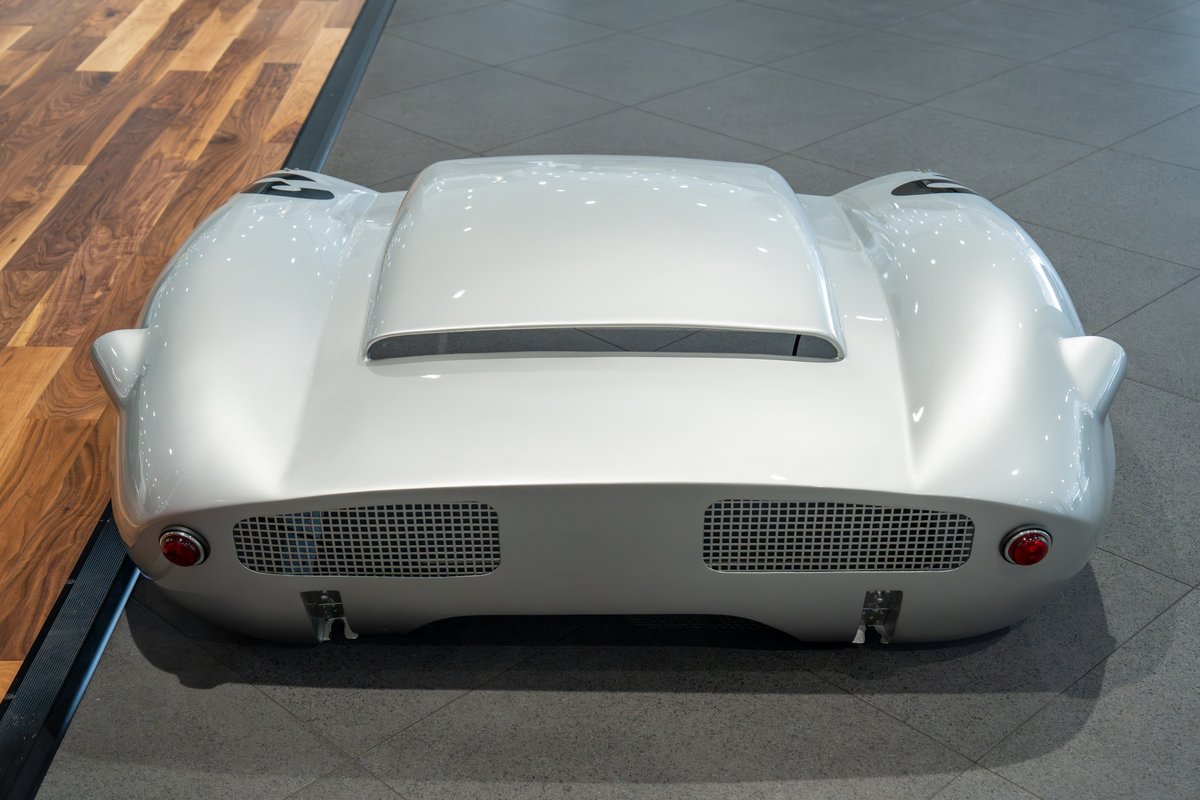 Silver 1964 Elva Porsche 4-Cam rear view, showcasing its streamlined body, grille, and round taillights.