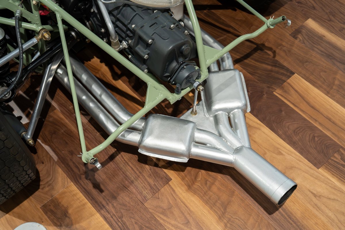 Close-up of the exhaust system and engine of a 1964 Elva Porsche 4-Cam race car.