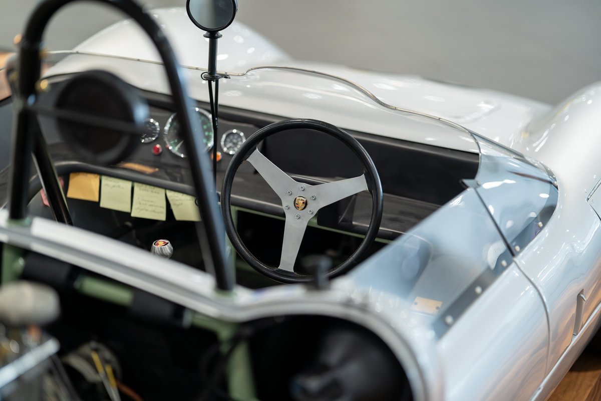 Interior of a silver 1964 Elva Porsche 4-Cam. Features vintage gauges and a three-spoke steering wheel.