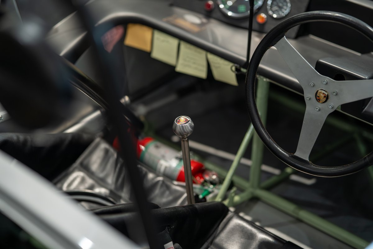 1964 Elva Porsche 4-Cam interior: racing steering wheel, metal shift knob, fire extinguisher.