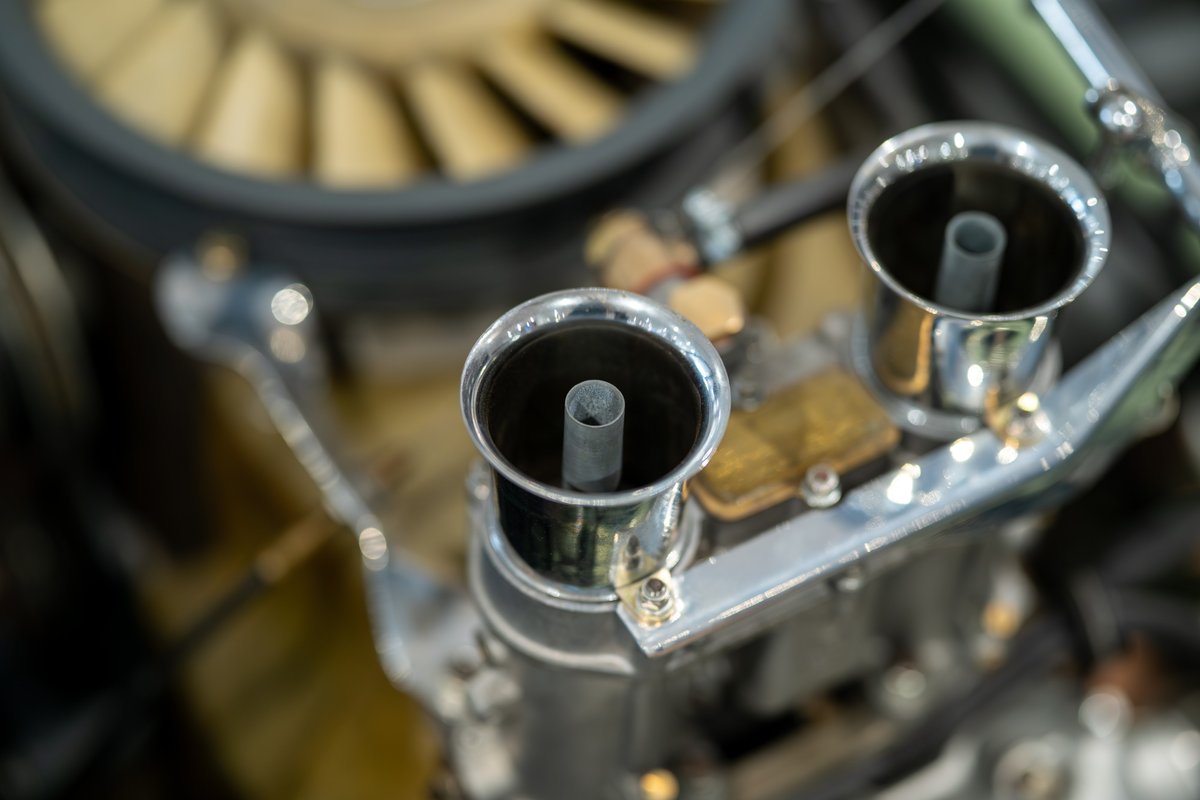 Vintage Elva Porsche 4-Cam with dual chrome velocity stacks and fan.