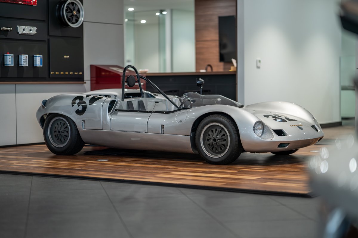 1964 Elva Porsche 4-Cam race car with silver livery, number 32, and black rims.