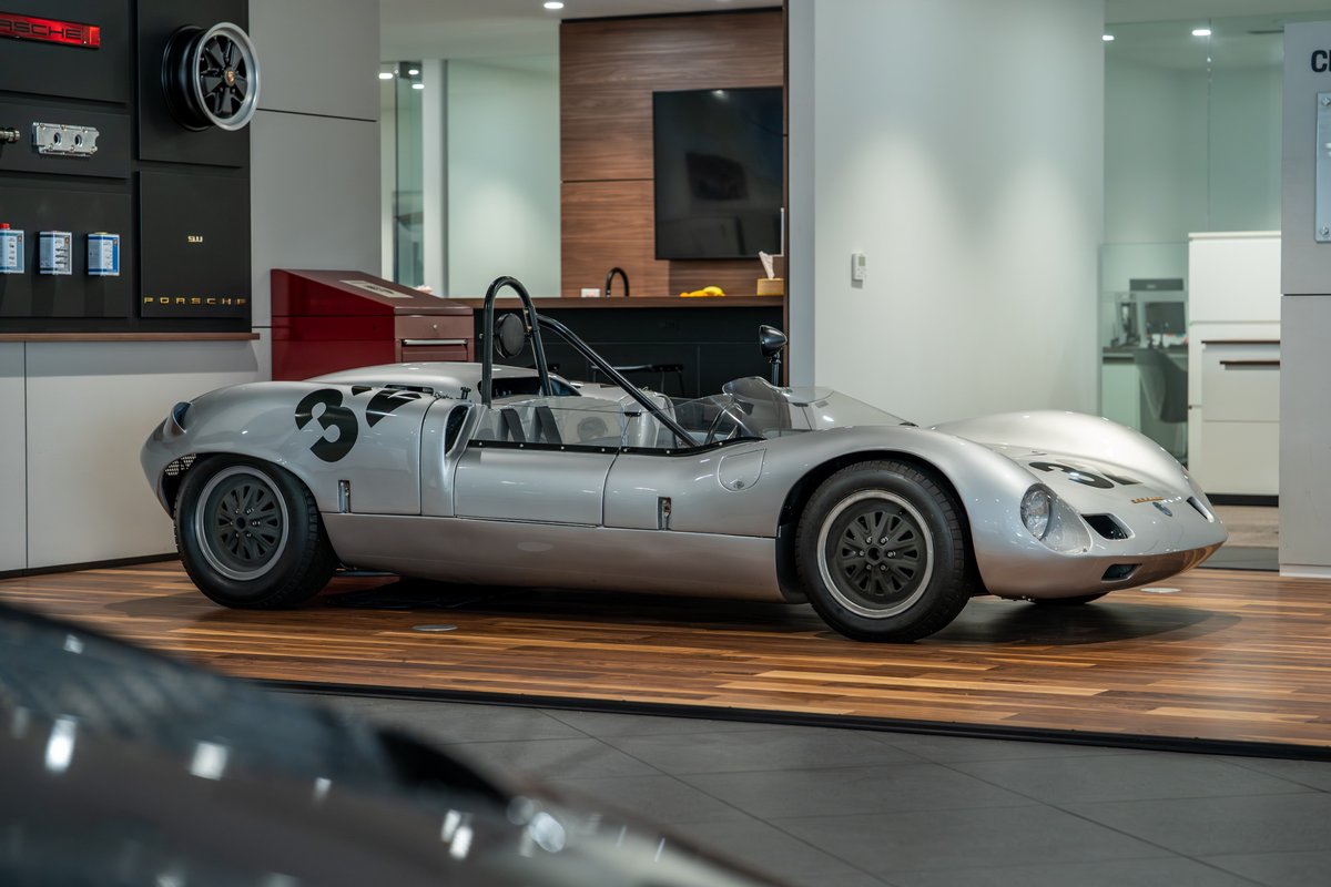 Silver 1964 Elva Porsche 4-Cam race car with number 33 livery and black rims.
