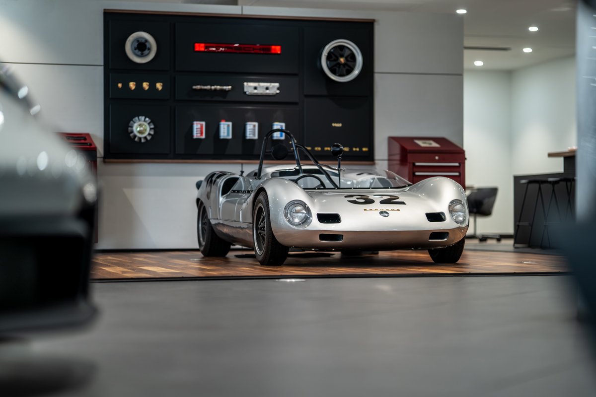 Silver 1964 Elva Porsche 4-Cam race car with #32 livery and classic chrome rims.