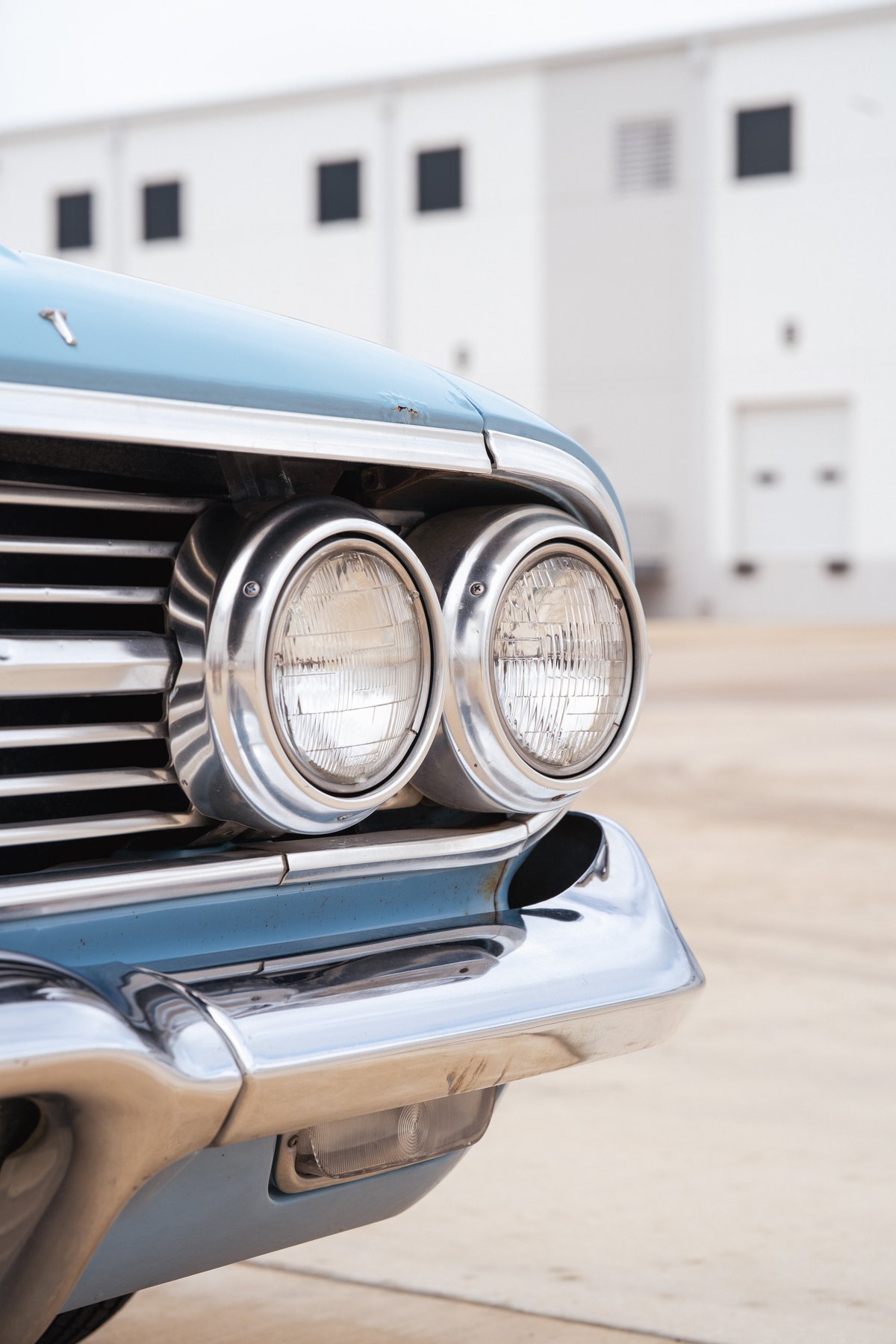 Front view of a classic blue 1963 Chevrolet Impala lowrider, featuring dual headlights and chrome trim.