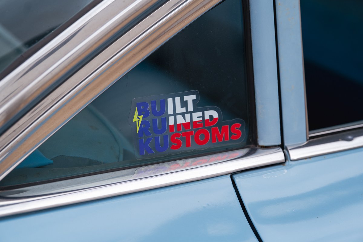 Classic light blue 1963 Chevrolet Impala lowrider with a "Built, Ruined, Kustoms" sticker on the window.