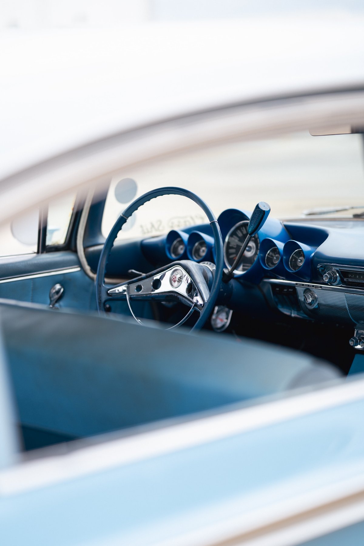 Interior of a blue 1963 Chevrolet Impala low-rider, featuring a blue steering wheel and dashboard trim.