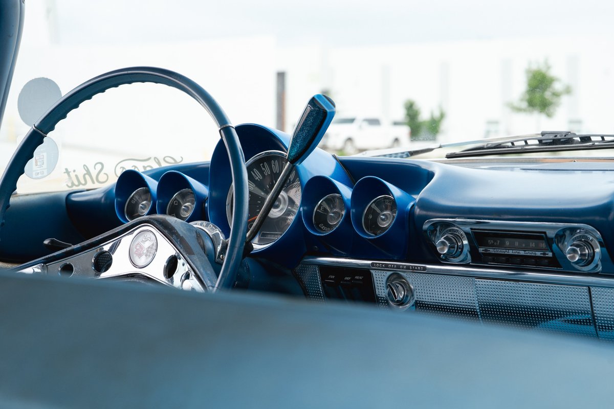 Blue 1963 Chevrolet Impala low rider interior with vintage dashboard and steering wheel.
