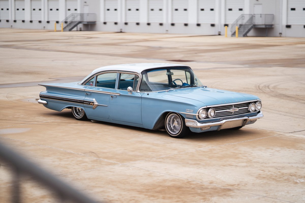 1963 light blue Chevrolet Impala lowrider, chrome rims, white roof, iconic tail fins