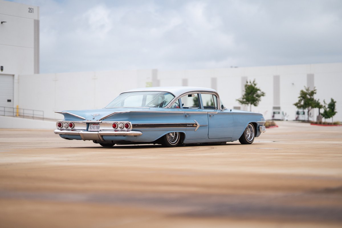 1960 light blue Chevrolet Impala lowrider with chrome rims and classic fins.