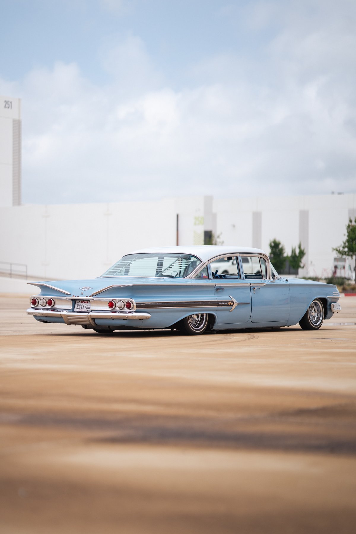 Lowrider 1959 Chevrolet Impala in baby blue with white roof and chrome rims.