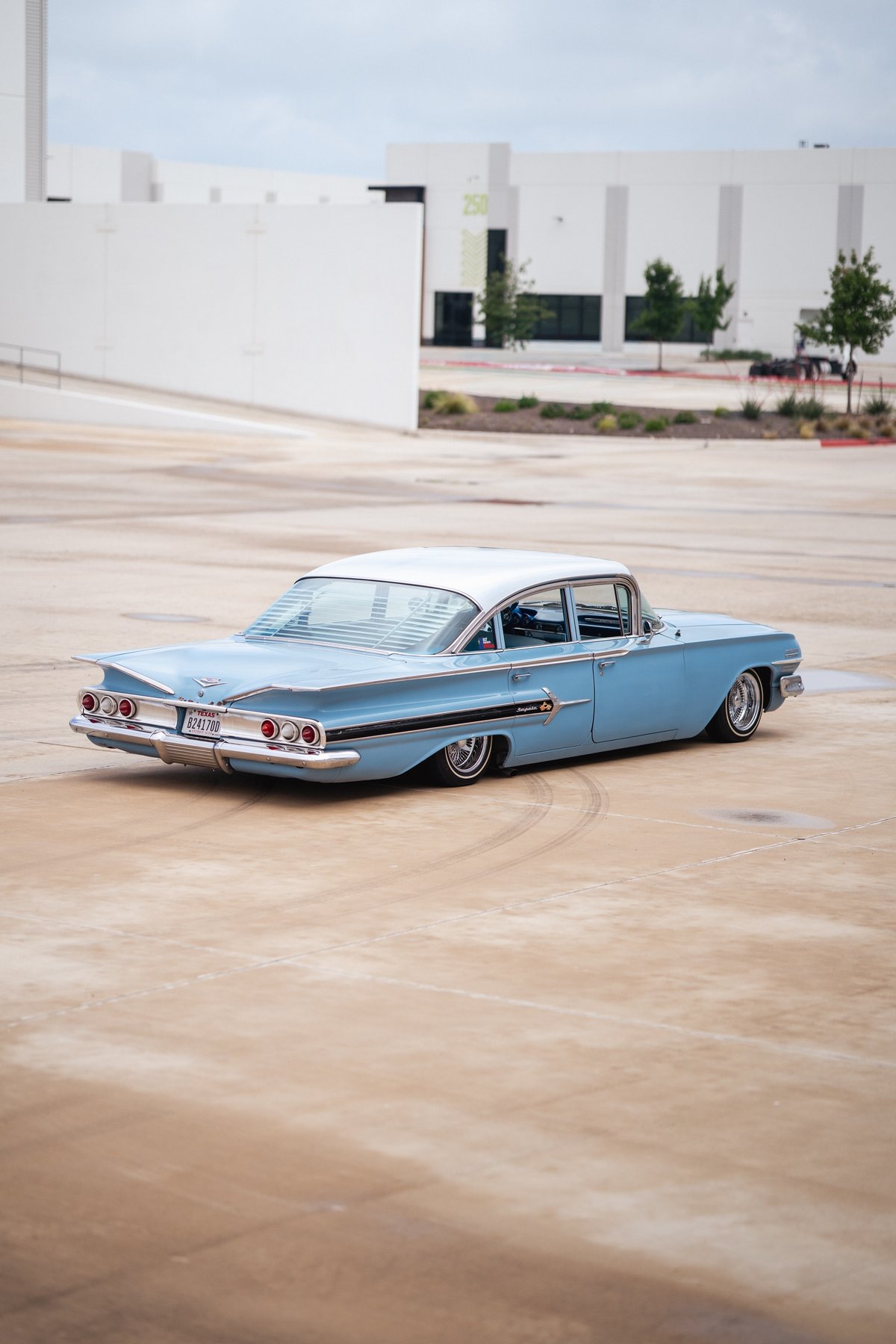 Low-rider 1959 blue Chevrolet Impala with chrome rims and classic fins.