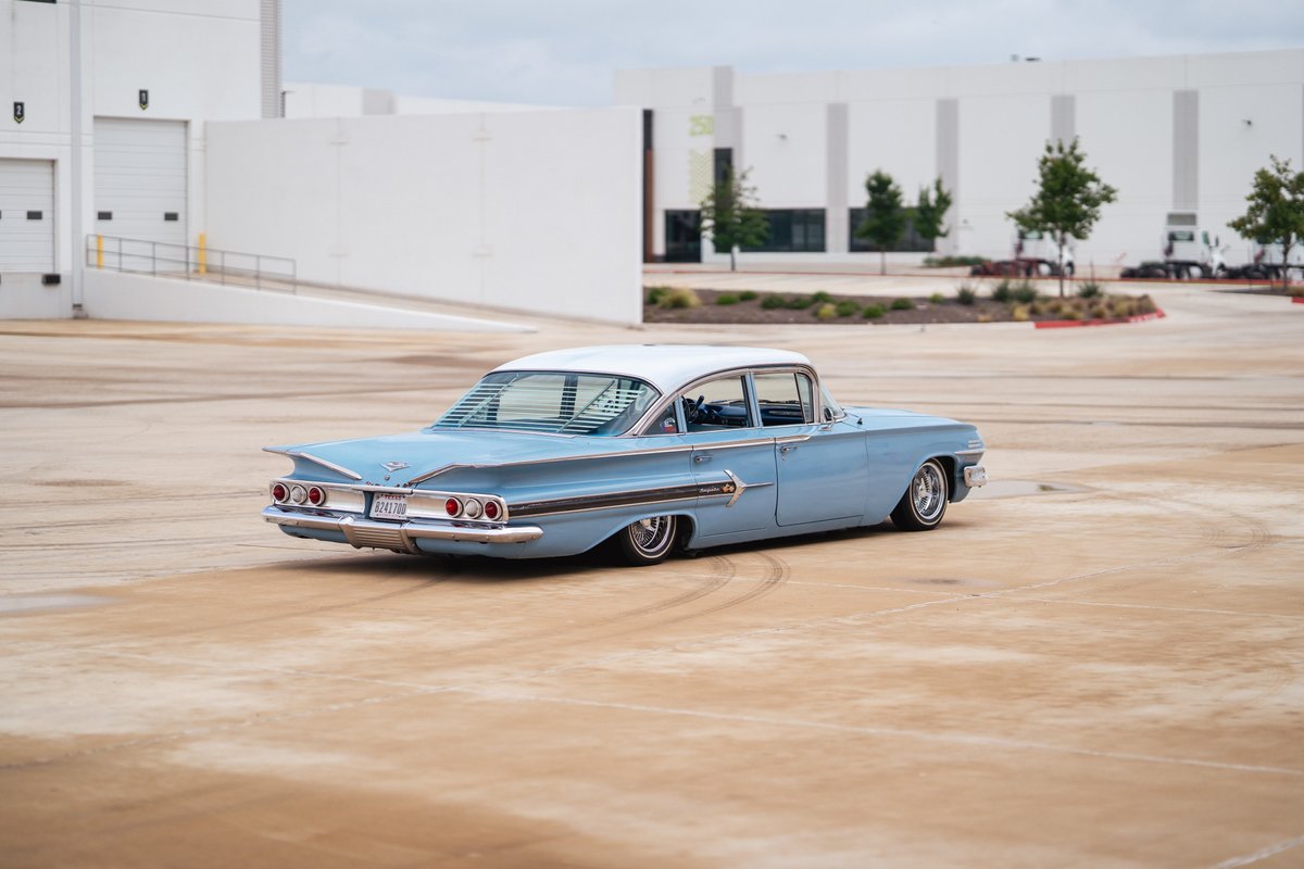 1960s light blue Chevrolet Impala lowrider with chrome rims and chrome trim.