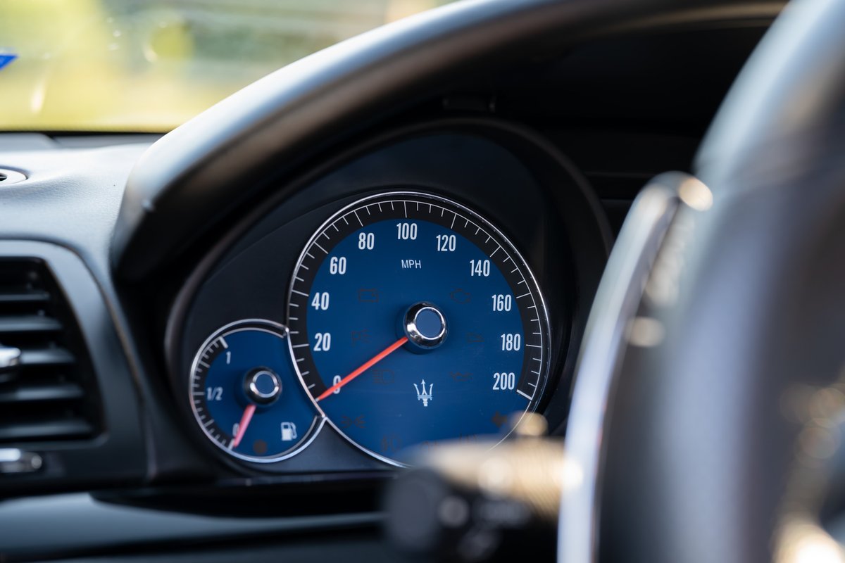 Close-up of the blue Maserati GranTurismo instrument cluster with tachometer and speedometer.