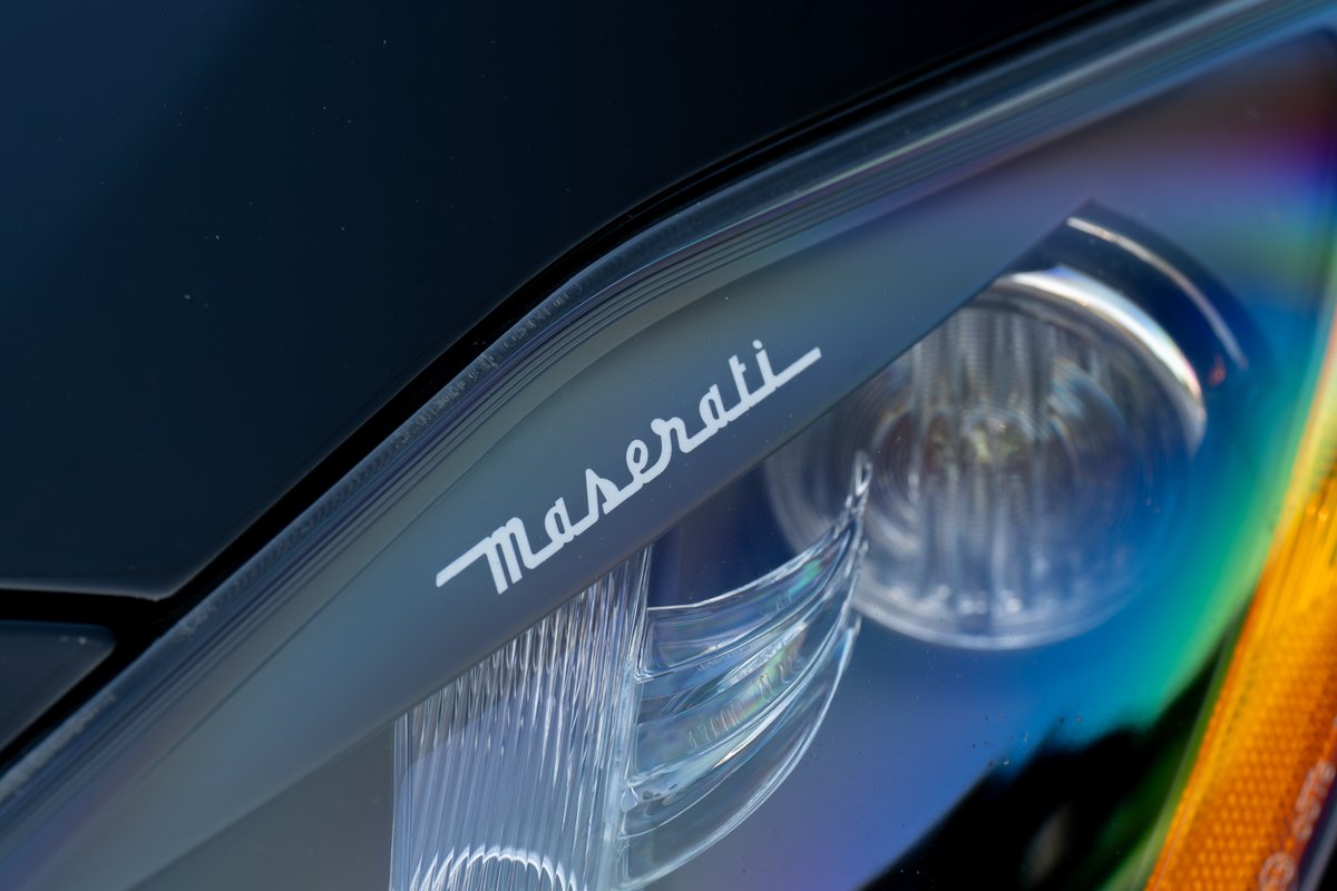 Close-up of a Maserati GranTurismo headlight trim with the Maserati script logo.