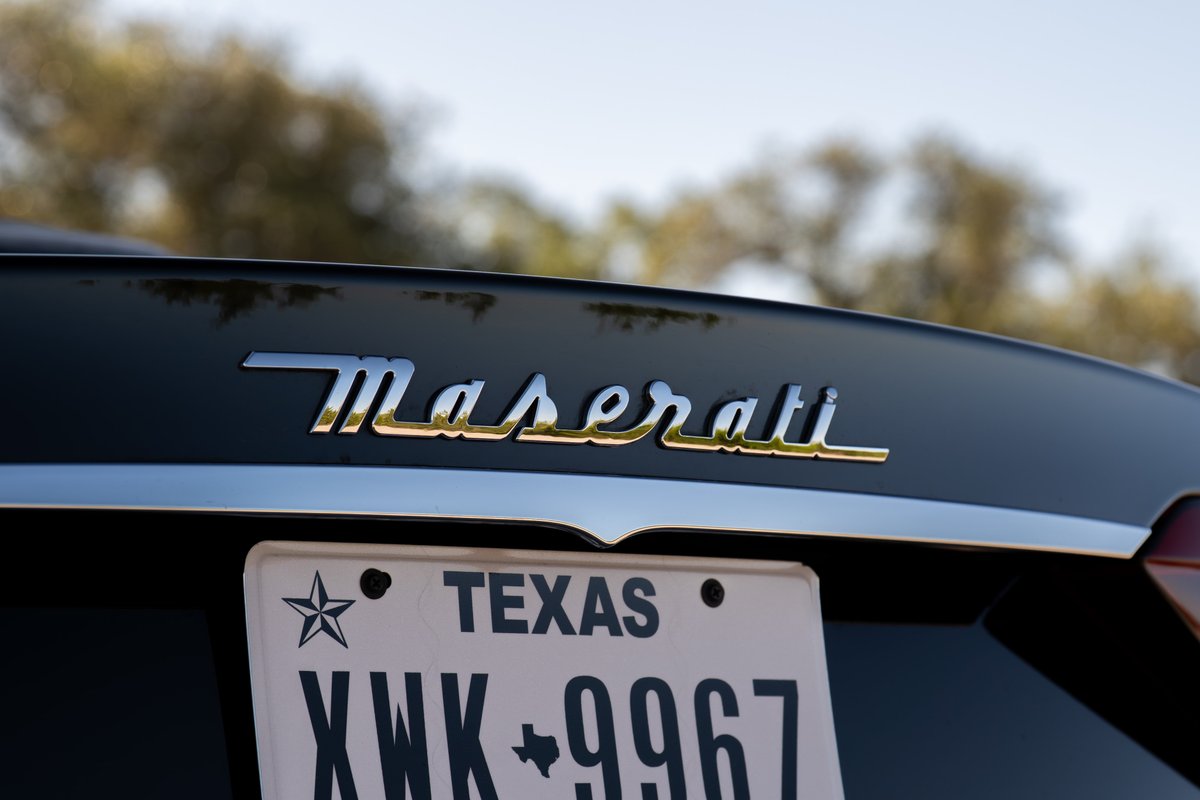 Maserati Granturismo badge on a dark car, with a Texas license plate.