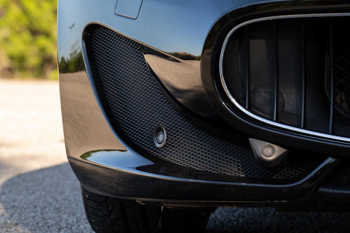 Black 2016 Maserati GranTurismo front bumper with parking sensors and honeycomb grille detail.