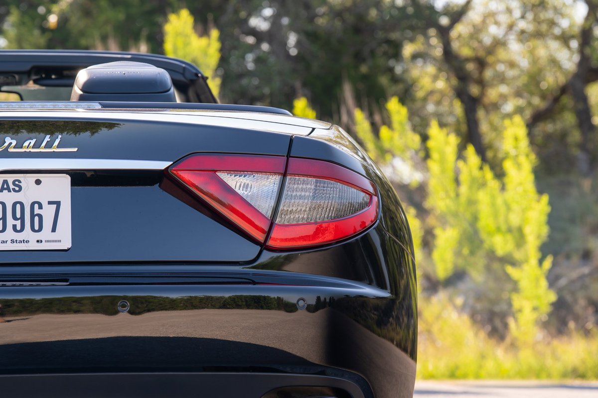 Rear view of a black 2016 Maserati GranTurismo convertible, showing taillight and license plate.