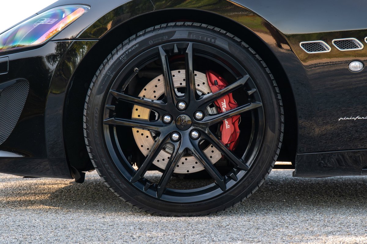 Black Maserati GranTurismo with red brake calipers and perforated rotors.