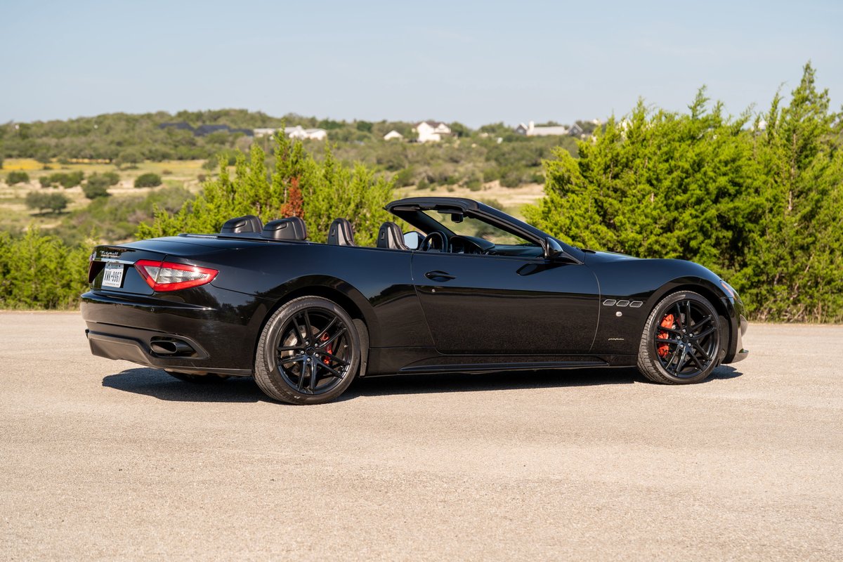 Black 2016 Maserati GranTurismo convertible with black rims and red brake calipers.