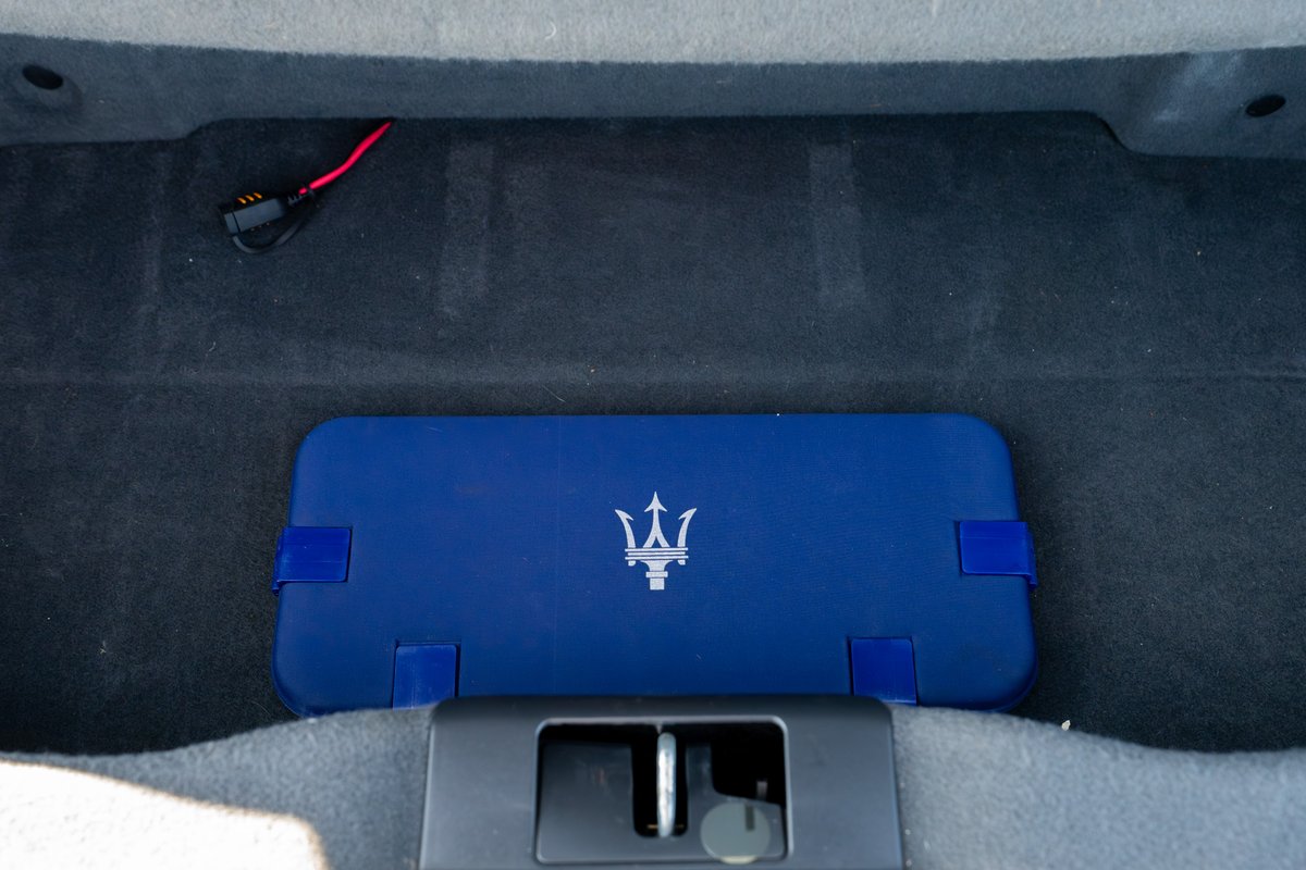 Maserati Granturismo trunk with blue Maserati logo case & charger.