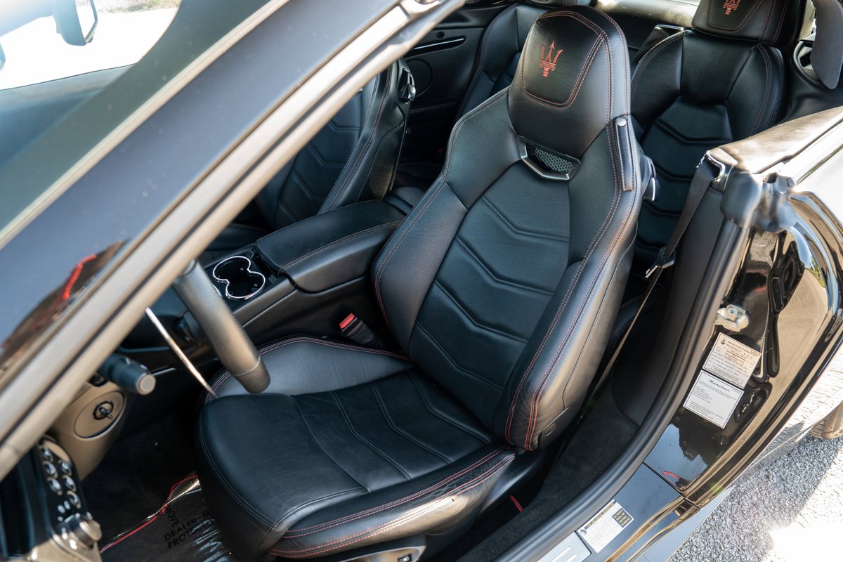 2016 Maserati GranTurismo interior showing black leather sport seats with red stitching.