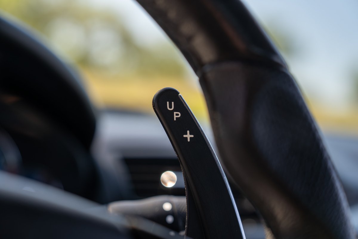 Maserati Granturismo steering wheel paddle shifter with "UP" and "+" markings.