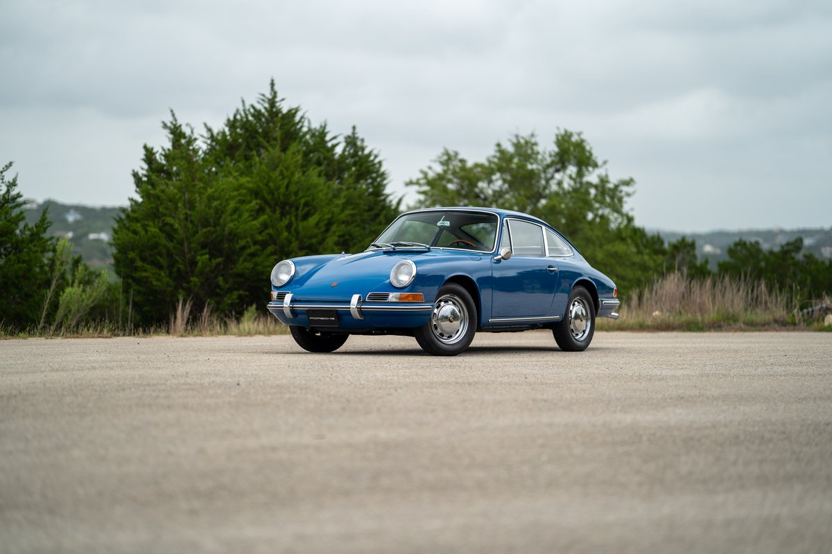 1965 blue Porsche 912 coupe with chrome trim and classic rims.
