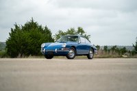 A blue 1965 Porsche 912 coupe with chrome rims and trim, parked outdoors.