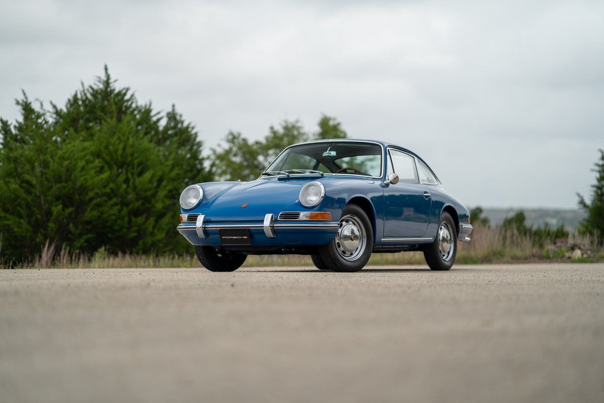 1965 Porsche 912 coupe in blue, featuring chrome rims and trim.