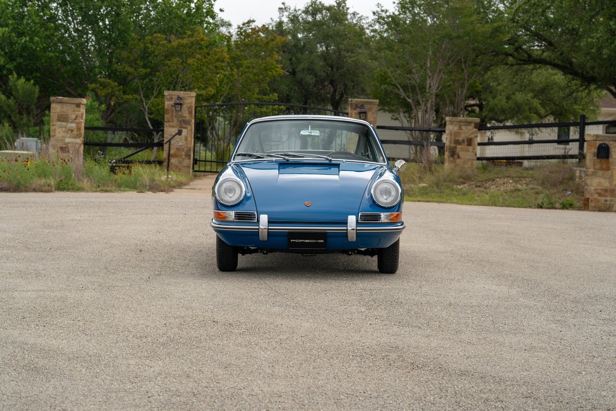 Front view of a classic blue 1965 Porsche 912 coupe with chrome trim.