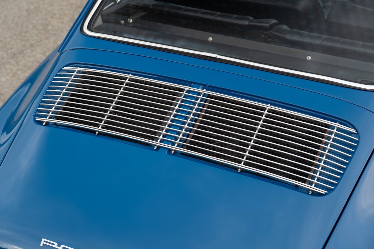 Close-up of a blue 1965 Porsche 912's rear deck lid with chrome grille.