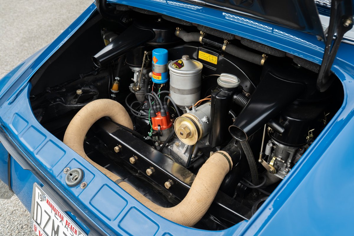 1965 Porsche 912 engine bay in blue, featuring twin Weber carburetors and exposed exhaust piping.