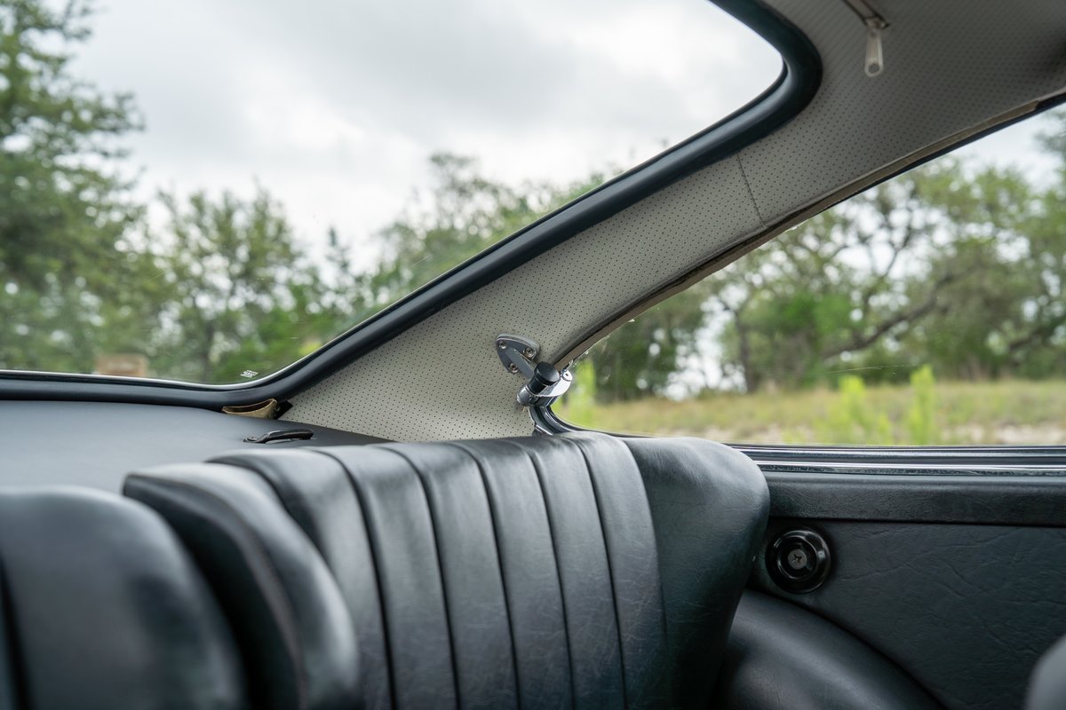 Close-up of the rear seat and perforated headliner trim of a 1965 blue Porsche 912 interior.