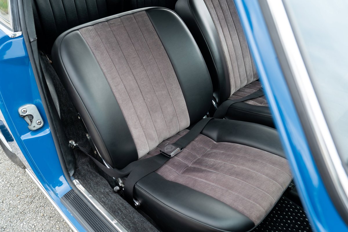 Close-up of the black and grey striped fabric seats with black leather trim in a blue 1965 Porsche 912.