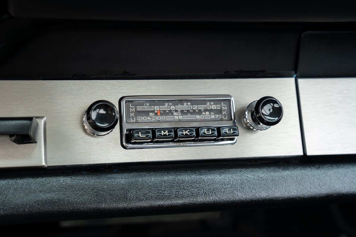 Vintage Porsche 912 dashboard with brushed metal trim and classic radio.