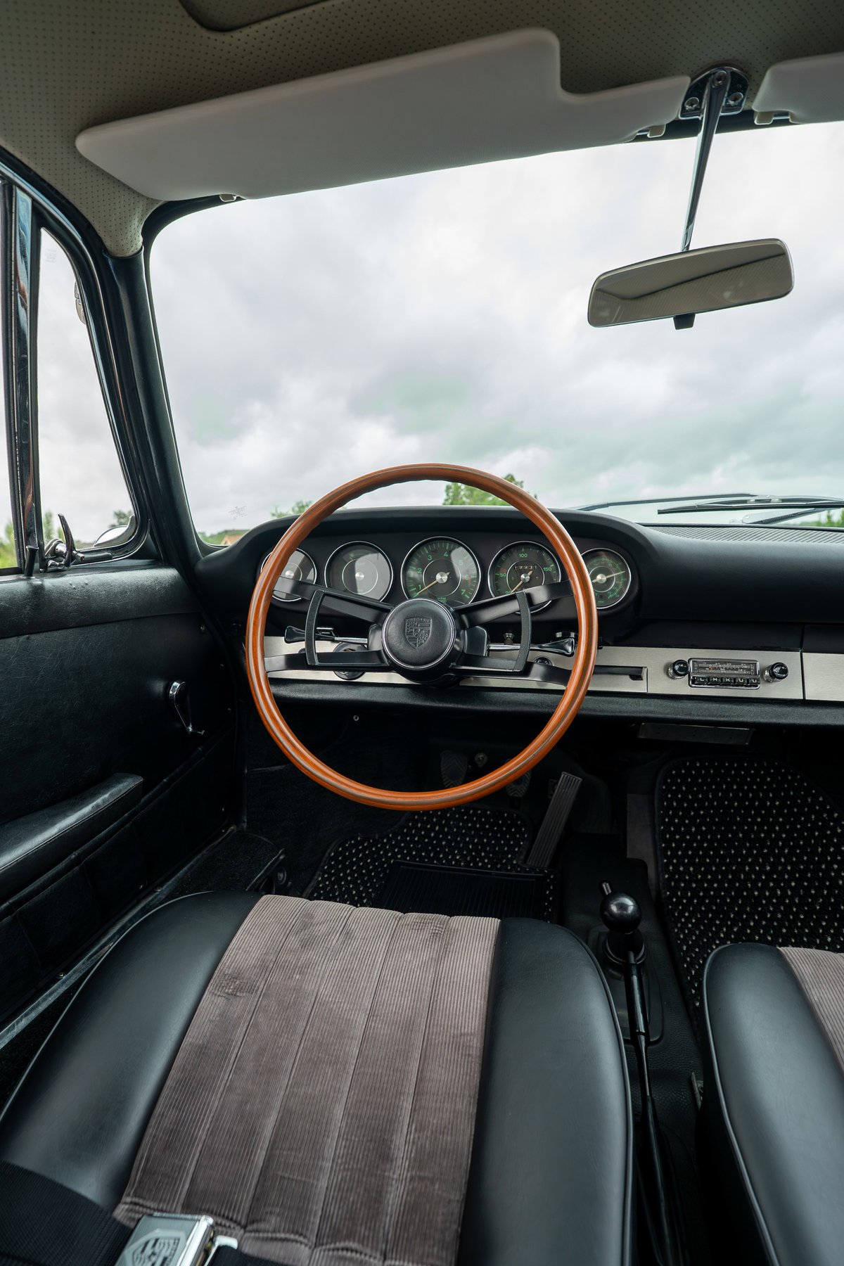 1965 Porsche 912 interior: wood-rimmed steering wheel, classic gauge cluster, corduroy seat inserts.