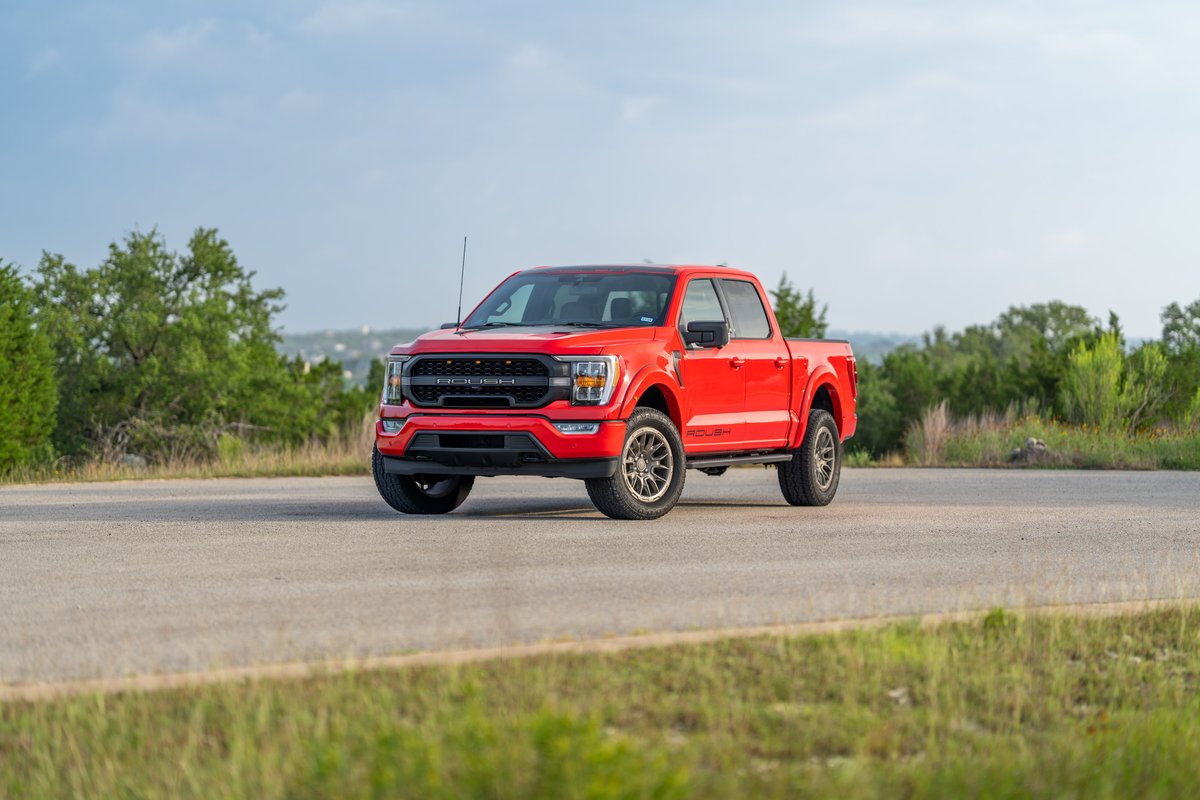 Red 2022 Ford F-150 Roush on rugged rims, with custom black trim and livery.