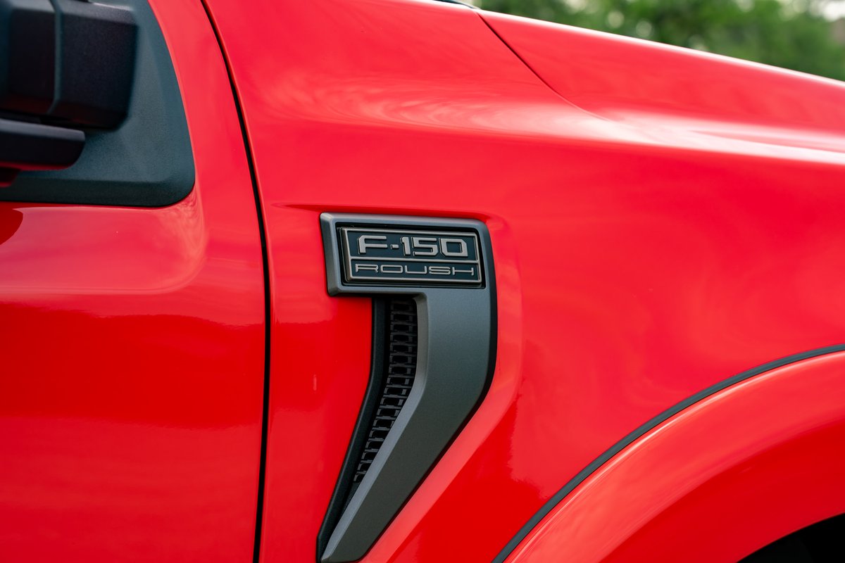 Close-up of a red 2022 Ford F-150 ROUSH fender vent and badging.